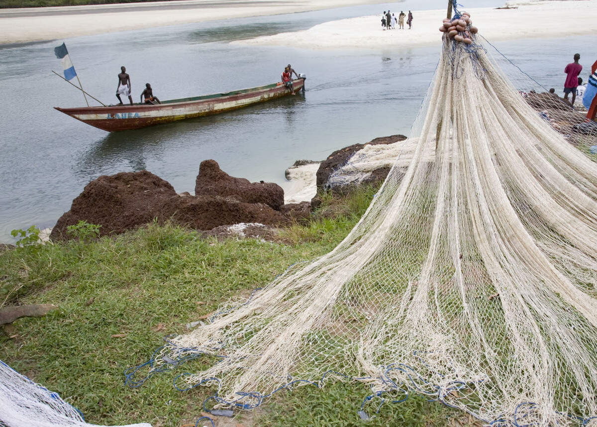 River No.2 on the Freetown Peninsula. A fishing boat returns home, where nets being mended along the white sandy beaches of River No.2. Once famed for it’s beautiful beaches, Sierra Leone now struggles to rebuild its tourism economy. August 2, 2006, For Leonard Pitts Story. ONE TIME USE ONLY. Once a world famous tourist destination today the locals are slowly trying to rebuild the industry after the civil war in hopes that one day much needed tourist dollars with flow again into the local struggling economy. Sierra Leone, August 2, 2006, For Leonard Pitts Story.