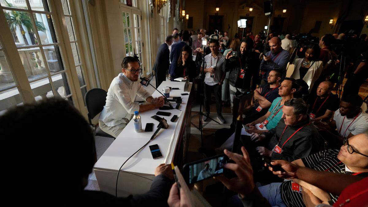 Reporters and cameramen surround Miami Dolphins football team head coach Mike McDaniel, as he answers questions at a coaches press availability during the NFL owner’s meeting, Monday, March 28, 2022, at The Breakers resort in Palm Beach, Fla. (AP Photo/Rebecca Blackwell)