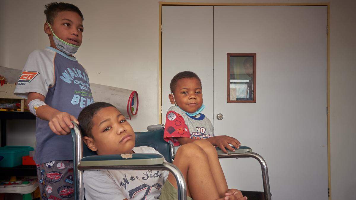 Abraham Estrada, 12, Andres Fernandez, 15, (in the wheel chair) and Winder Rangel, 9, are waiting for their lunch.