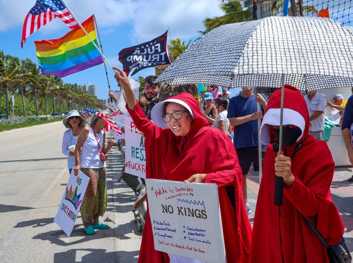 Alex Coss, center, of Fort Lauderdale dressed as a character of “The Handsmaid”s Tale” while protesting with others on A1A. At its peak between 400-500 protestors gathered at Fort Lauderdale’s No Kings Protest on the A1A and Sunrise Boulevard Saturday. The rally was just one of hundreds being held across the country on the birthday of President Trump, Saturday, June 14, 2025.