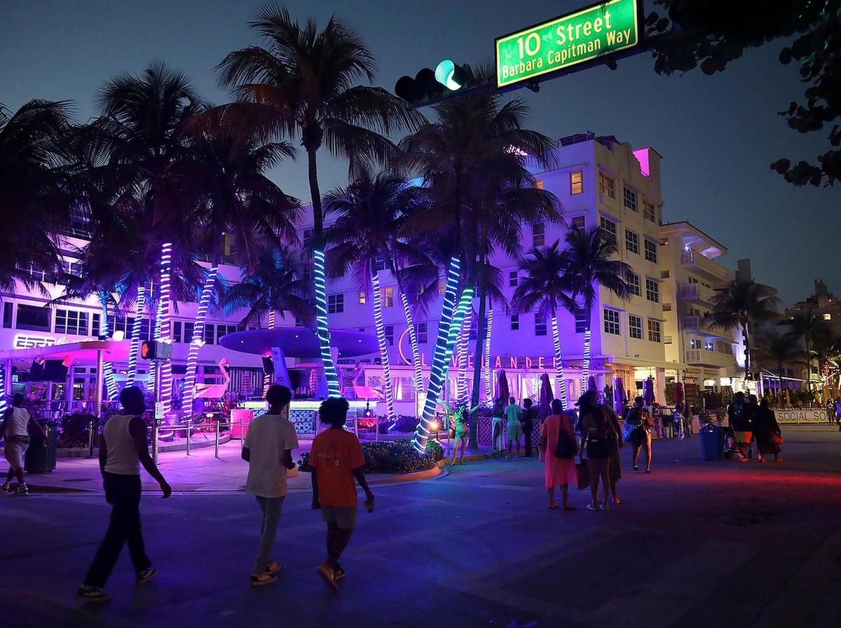 A sparse crowd of spring break visitors promenades Ocean Drive as the citywide curfew went into effect, with police presence evident at most intersections of Collins Avenue on Thursday, March 25, 2021.