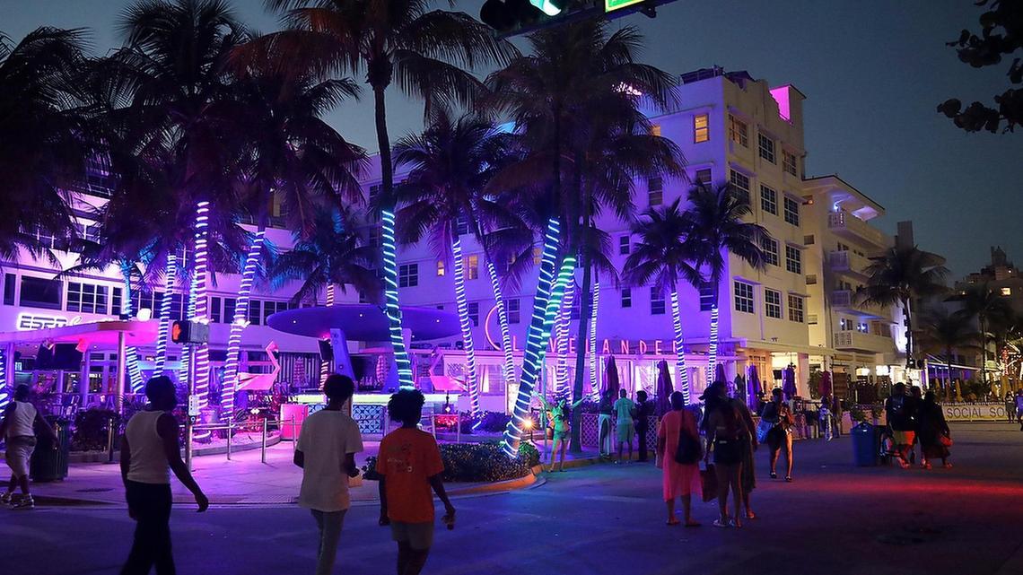 A sparse crowd of spring break visitors promenades Ocean Drive as the citywide curfew went into effect as police presence was evident on most intersections of Collins Avenue on Thursday, March 25, 2021.