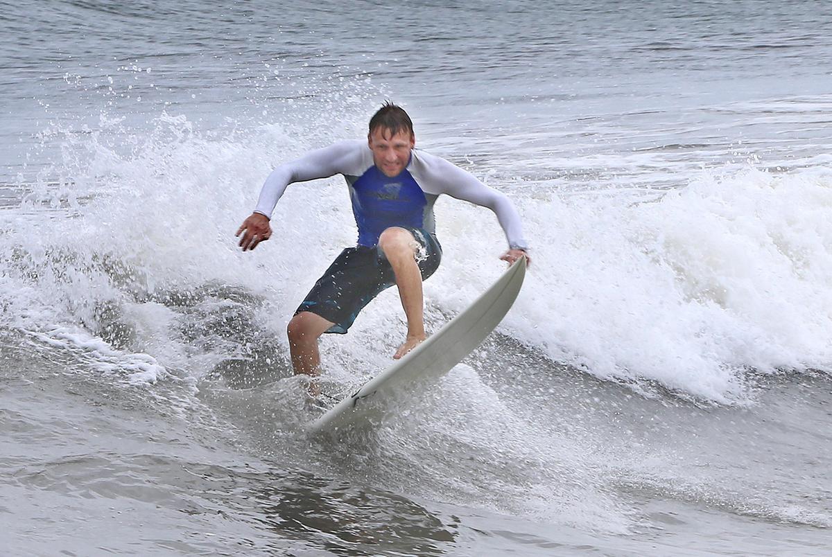 A surfer rides the waves on Spanish River Park beach in Boca Raton as Hurricane Dorian stalls around 100 miles to the east over the ocean on Monday, Sept. 2, 2019.