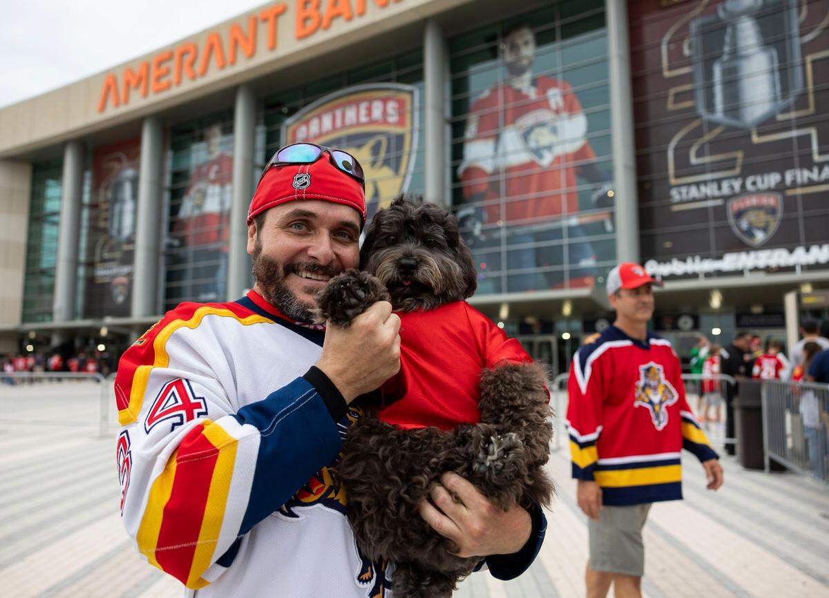 Florida Panthers fan Jorge Ulloa, 48, and his dog, Rocky, arrive to a watch party at the Amerant Bank Arena to see their team play against the Edmonton Oilers in Game 4 of the NHL Stanley Cup Final