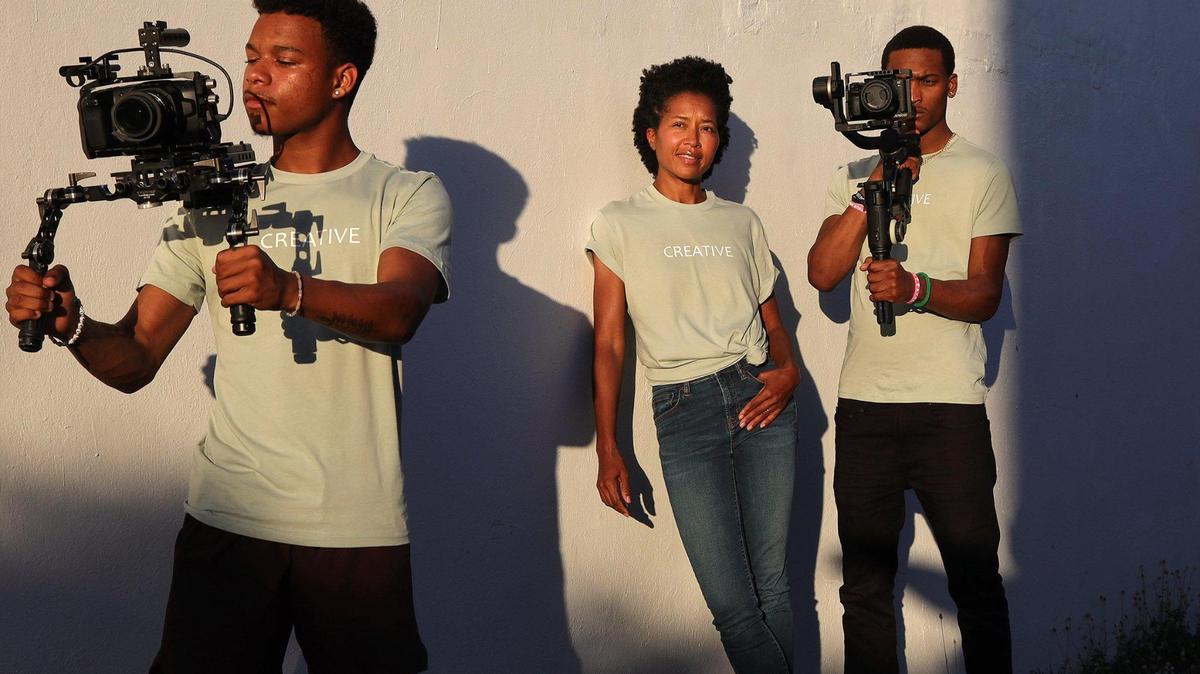Creative Media Group founder Maria Taylor, 43, center, stands near Giovanni Carter, 18, left, and Julien Pierre-Louis, 38, right, two of the many young filmmakers her company helps to learn about film production on Thursday, Jan. 6, 2022, in Miami.