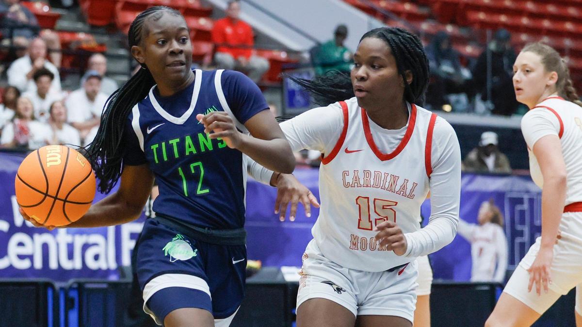 SLAM Miami Titans Jim’Miyah Branton (12) drives the ball as Cardinal Mooney’s Sy’monique Simon defends in the first half during girls 3A basketball semifinal game of the Florida High School State Championships at the RP Funding Center in Lakeland, Florida on Friday, February 28, 2025.