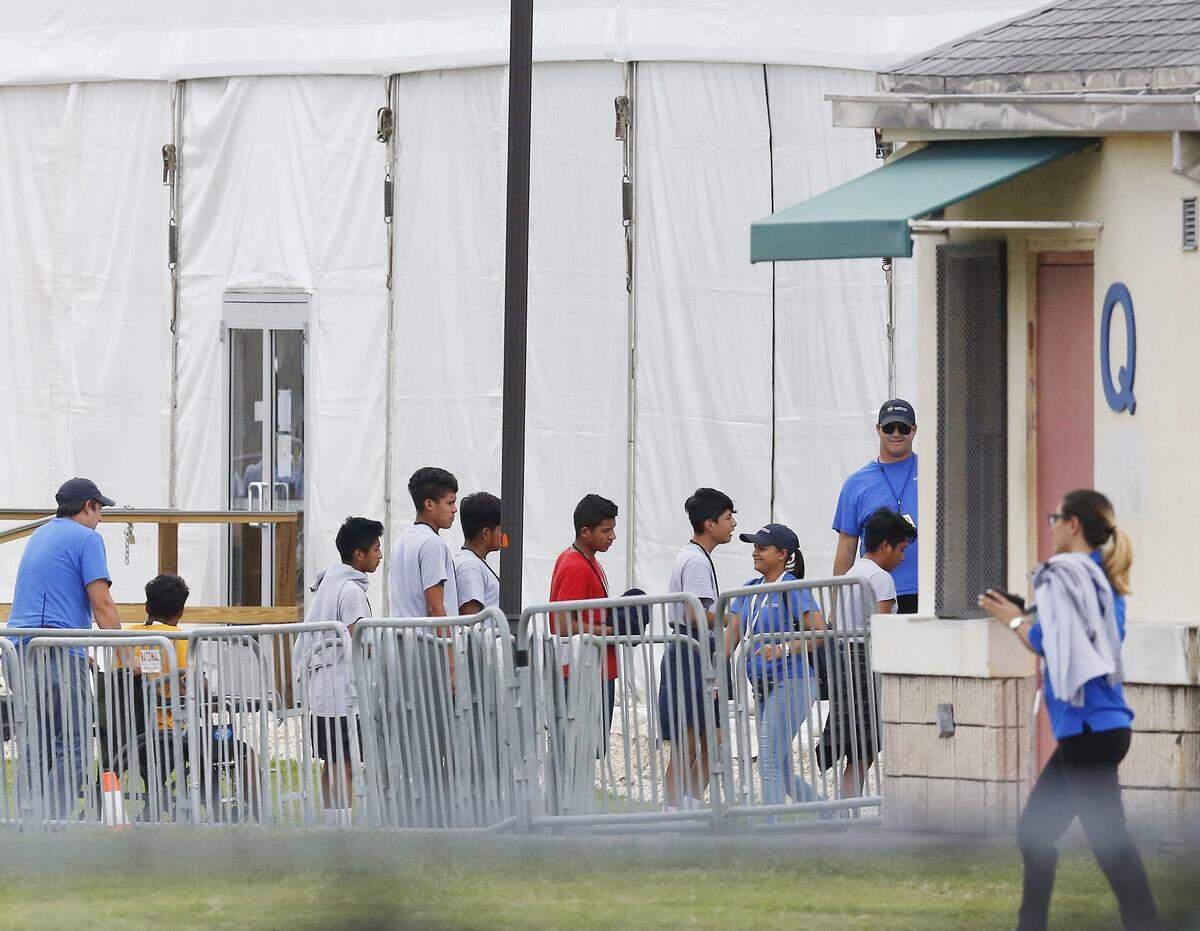 In this June 20, 2018, file photo, immigrant children walk in a line outside the Homestead Temporary Shelter for Unaccompanied Children a former Job Corps site that now houses them in Homestead.