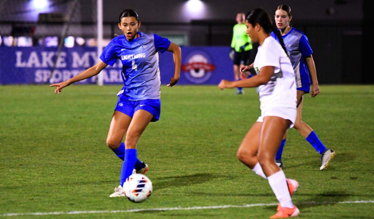 Cypress Bay junior Atika Hassan battles for possession of the ball with a Jupiter defender during a Class 7A girls soccer semifinal on Monday at Lake Myrtle Sports Complex in Auburndale.