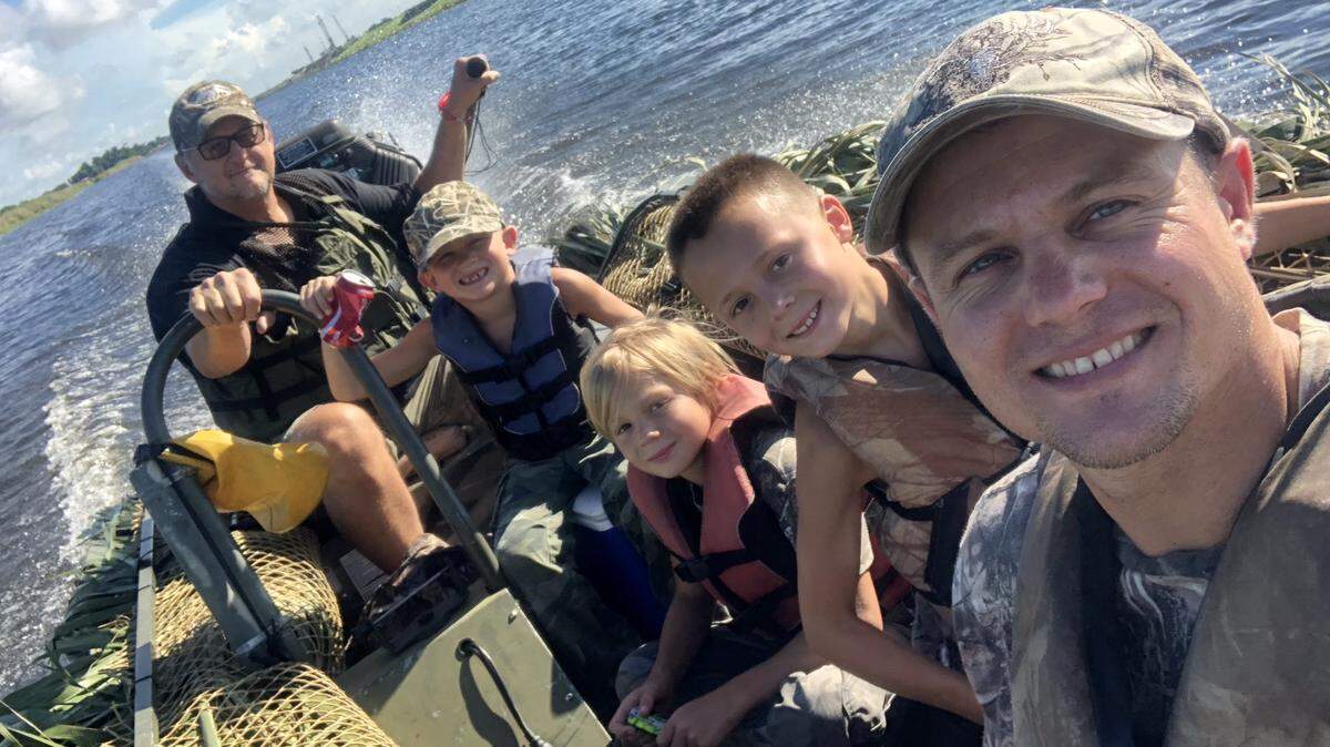 Ron Smith drives his duck boat back from a successful youth hunt this past February with grandsons Logan, left, Urijah, Hunter and their father Micah.
