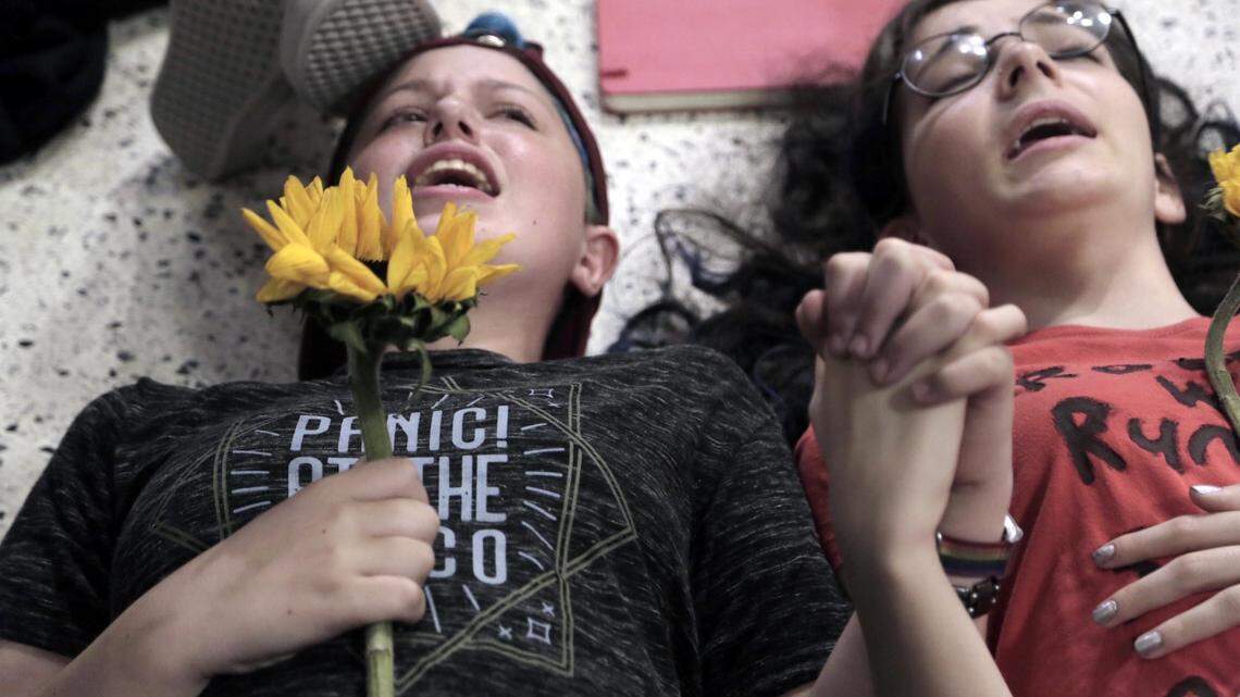 Two young protesters lie on the floor of the Publix store in Coral Springs Friday, May 25, 2018, for a 12 minute "die-in" to protest Publix's support for Adam Putnam's gubernatorial campaign.
