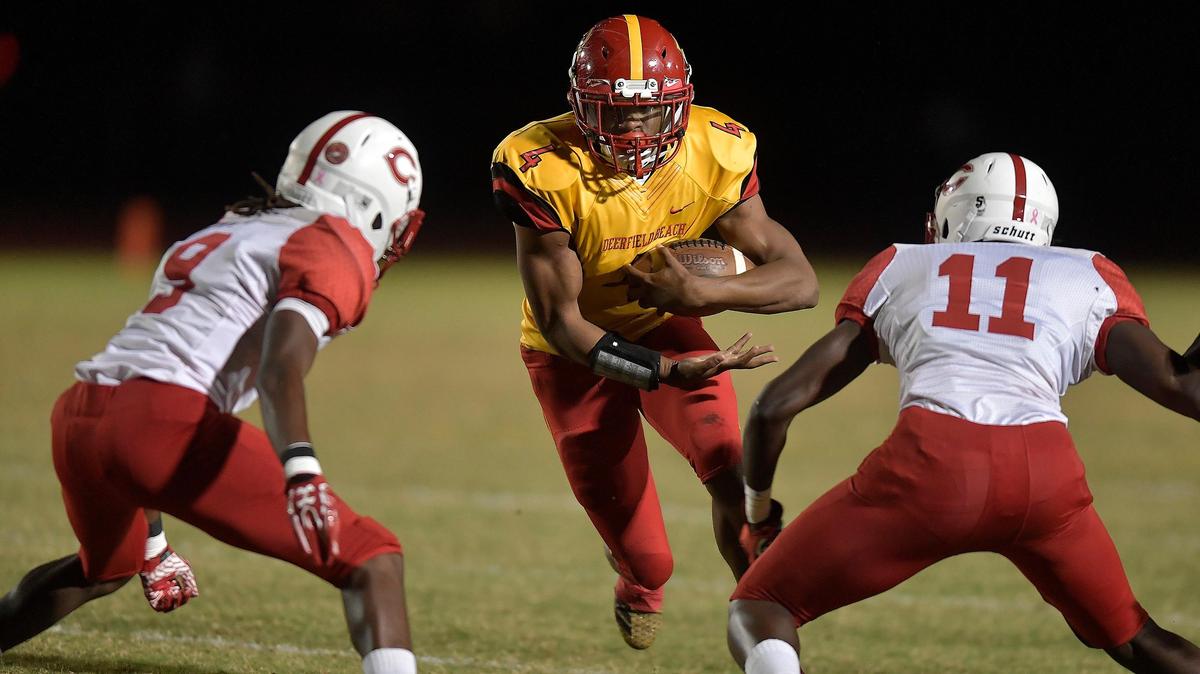 Deerfield Beach’s Jaylan Knighton tries to run through Plantation’s Keyon Todd and Jakeem Hall during the first half of their 8A football regional semifinal game, Friday, Nov. 16, 2018, at Deerfield Beach High School.