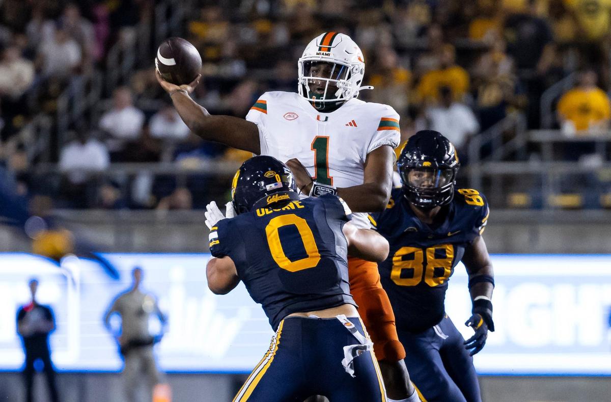 Miami Hurricanes quarterback Cam Ward (1) looks to throw the ball as California Golden Bears linebacker Cade Uluave (0) tries to tackle him in the first half of their NCAA college football game at the California Memorial Stadium on Saturday, Oct. 5, 2024, in Berkeley, Calif.