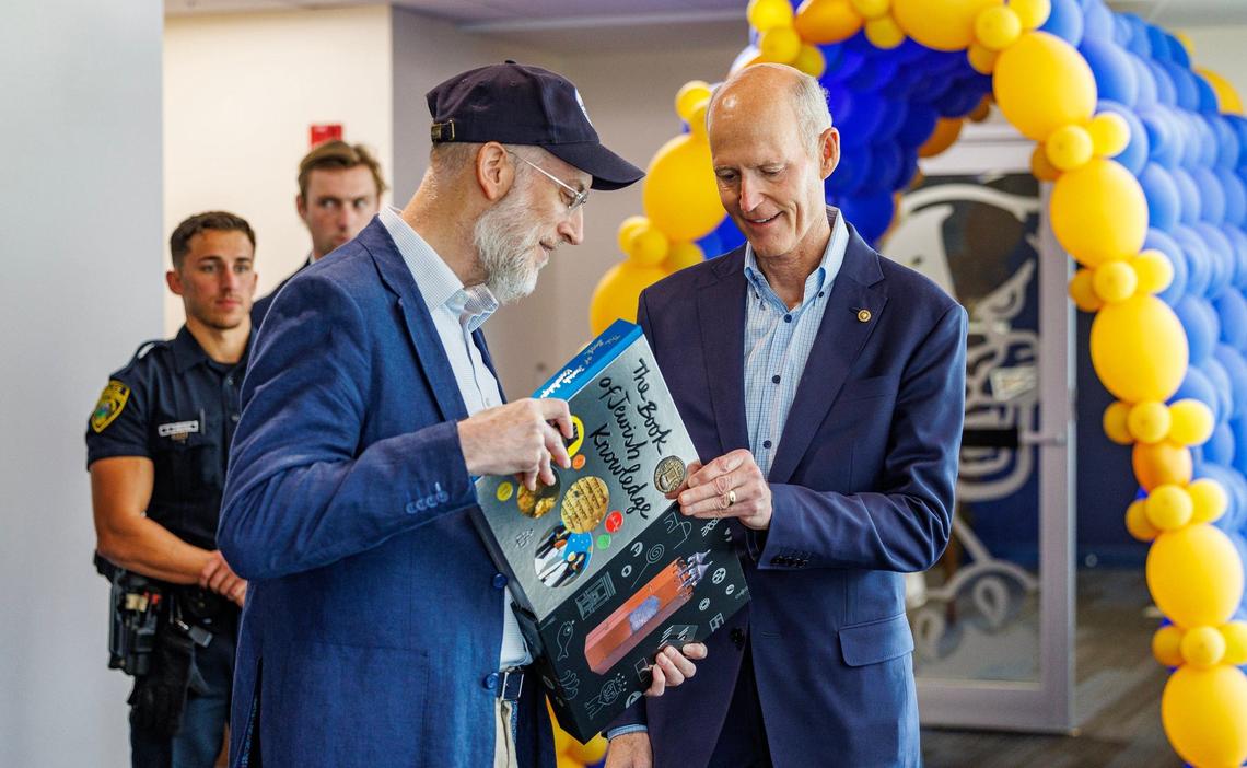 Florida U.S. Sen. Rick Scott (right) received a book from Eric Rappaport, councilman at the Town of Bay Harbor Islands, as he arrives for the Floridians Against Anti-Semitism roundtable event at Florida International University, in Miami, on Friday Sept. 20, 2024.