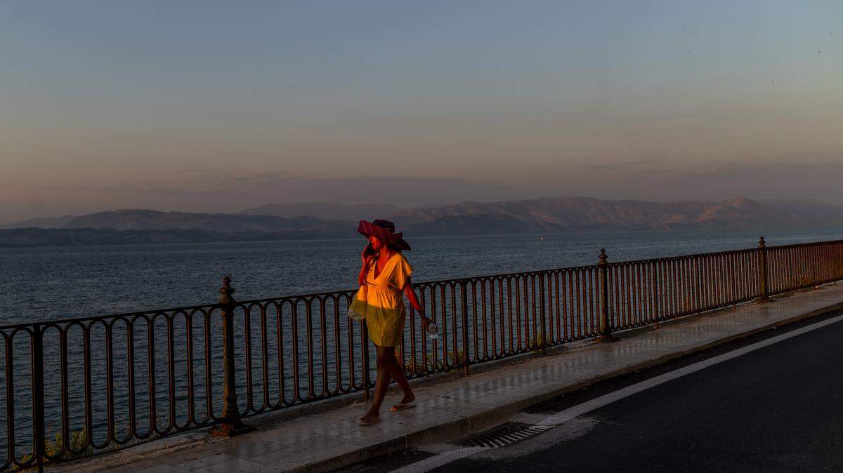 A woman walks near a beach in old town of Corfu island on July 1, 2020 as the island welcomes its first tourists after months of closure due to the spread of the Covid-19 disease caused by the novel coronavirus.