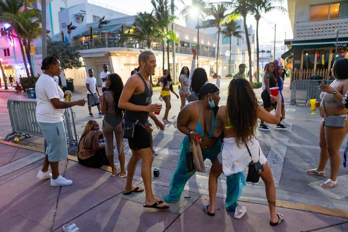 A group of tourists dance on Ocean Drive during spring break in Miami Beach on Monday, March 22, 2021.