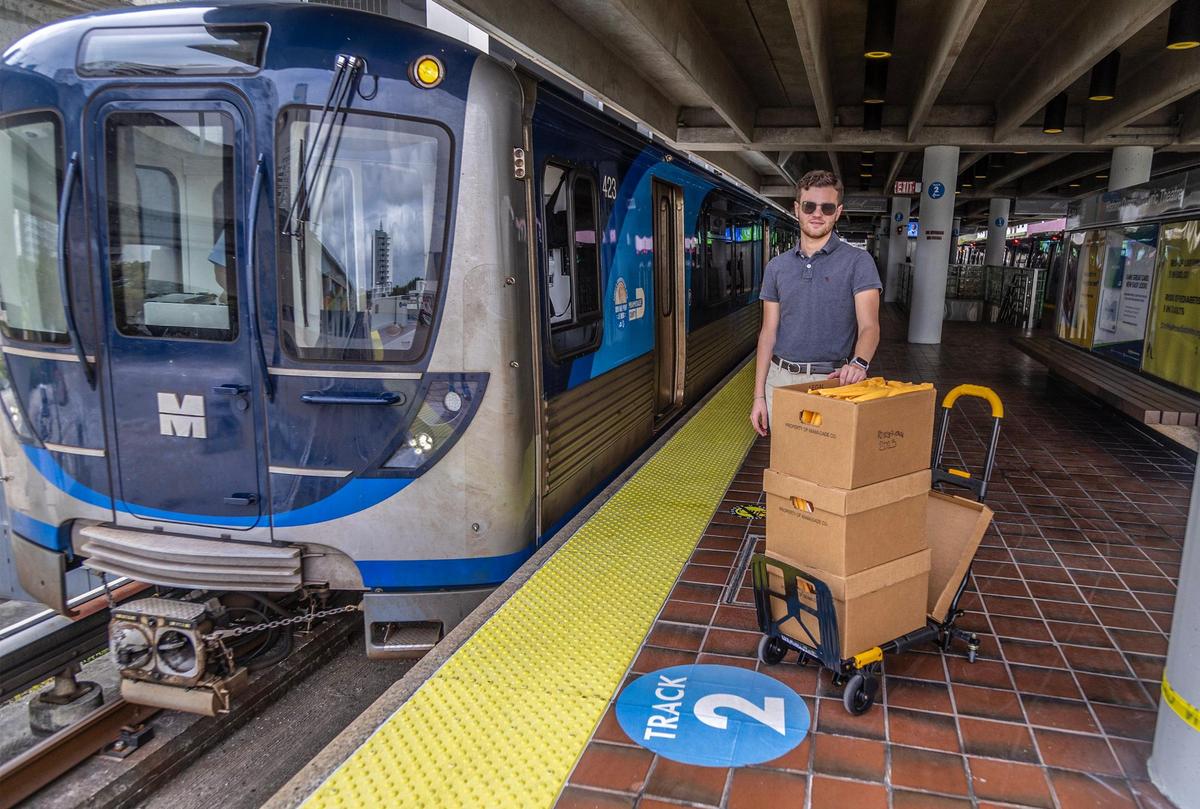 Transit advocate Kevin Amézaga posed at the Overtown Metrorail station platform with boxes full of Metrorail’s public records he got from the Miami-Dade County as he tries to unearth why Metrorail can be so late sometimes. Photographed on Friday October 27, 2023.