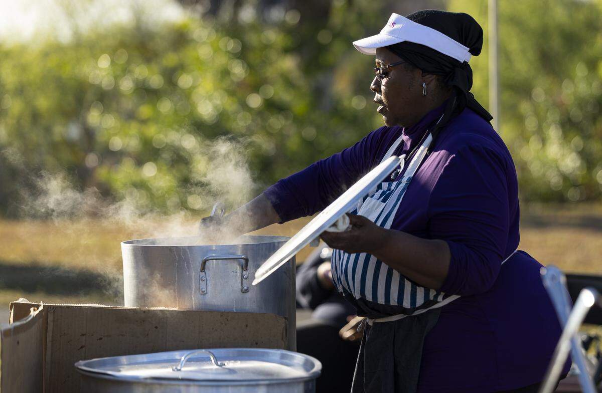 Sophia Collins, working with Kravinz, prepares vegetable soup for sale at the Reggae Genealogy music festival at Volunteer Park.