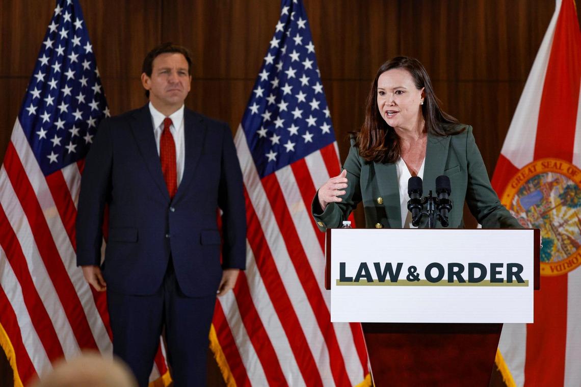 Florida Attorney General Ashley Moody speaks as Gov. Ron DeSantis listens during a press conference proposing anti-crime legislation at the Police Benevolent Association in Miami on Thursday, Jan. 26, 2023.