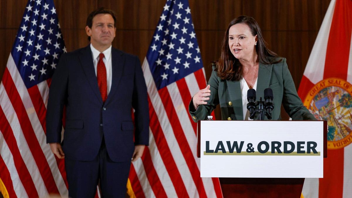 Florida Attorney General Ashley Moody speaks as Gov. Ron DeSantis listens during a press conference proposing anti-crime legislation at the Police Benevolent Association in Miami on Thursday, January 26, 2023.