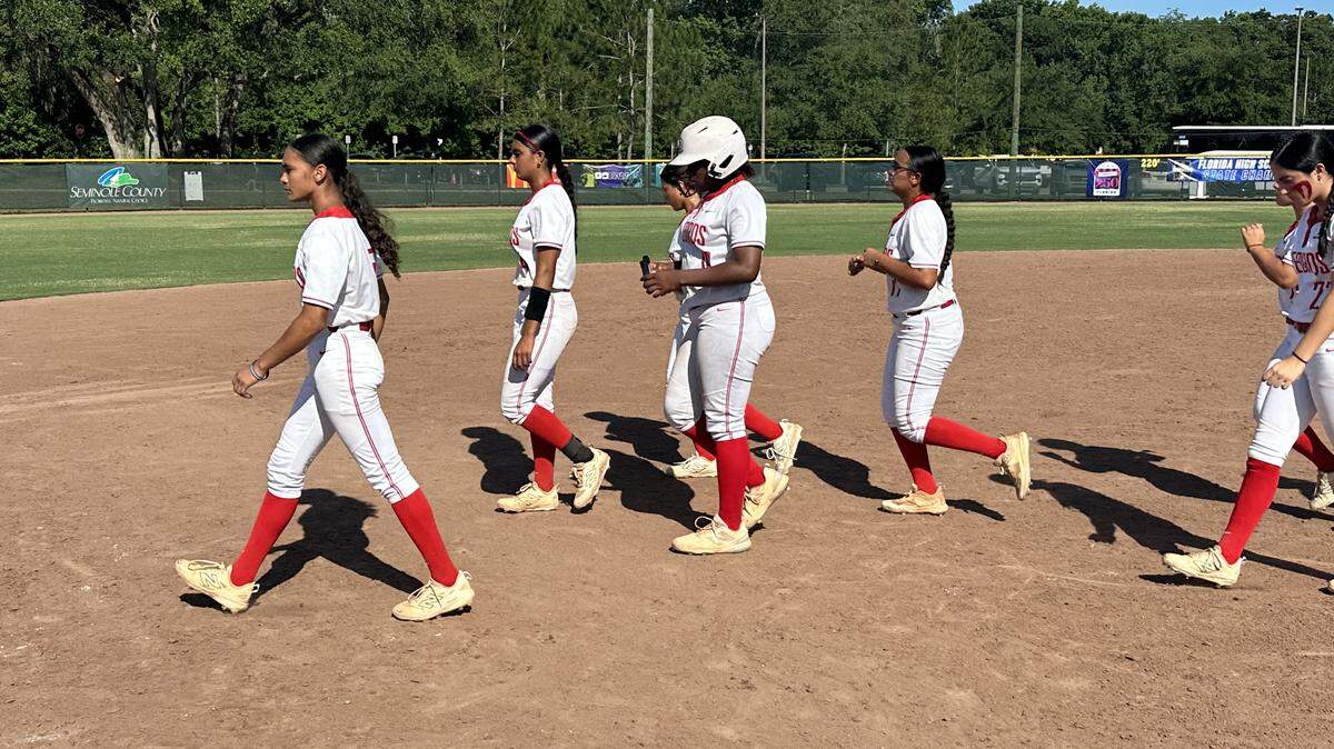 Doral Academy softball players walk off the field somber after losing to Bartow 10-8 in a Class 6A state semifinal on Friday at Boombah-Soldiers Creek Park in Longwood, Fla.