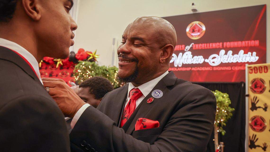 Norland graduate Triston Wilson, left, receives his pin from his father, Paul V. Wilson Jr., with pride and joy during the 31st consecutive year of the Wilson Scholars Academic Signing Ceremony of the 5000 Role Models of Excellence Project connected Wilson Scholars from public high schools in Miami to full scholarship support to prestigious colleges and universities during its ceremony held at the Miami Dade College-North Campus SOJ Multipurpose Room on Sunday, June 9, 2024 in Miami, Florida.