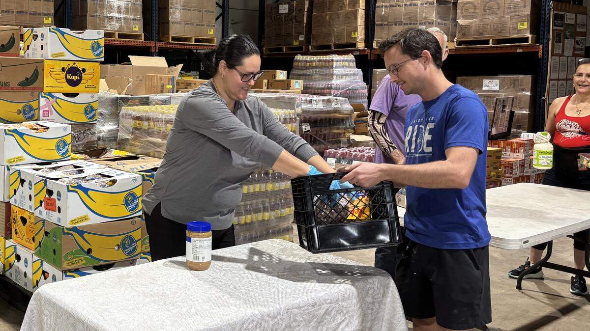 Volunteers pack crates with food items at Matthew 25, a food pantry owned and operated by Catholic Charities. The food pantry serves 1,300 families per month, but is currently experiencing a shortage in protein items.