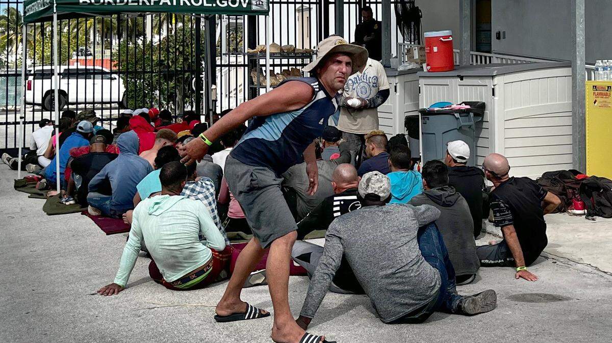 Cuban migrants sit outside a Border Patrol station while waiting to be processed. On Wednesday, Jan. 4, 2023, about 40 men, women and some small children entered the next stage in their migration from Cuba to the United States when they were processed by the Border Patrol at the agency’s station in the Middle Florida Keys city of Marathon. They were among hundreds of people from Cuba, and one large group of 130 people from Haiti, who’ve landed across the island chain since the end of last week.