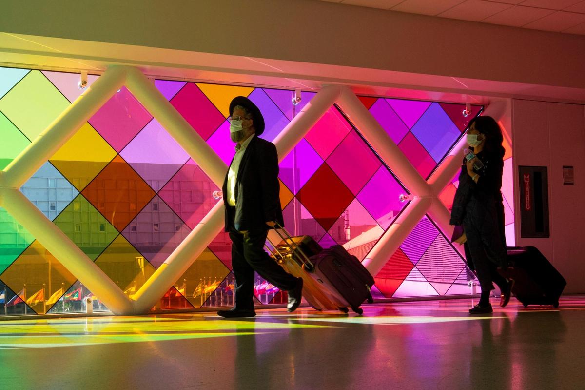 Travelers walk through Miami International Airport in Miami, Florida, on Monday, November 22, 2021.