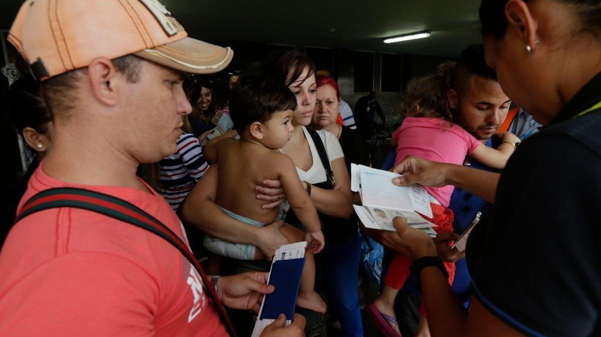 A migration officer checks the documents of Cuban migrants before they board a chartered flight in Panama City in May. U.S. officials are urging Latin American governments to stem the tide of Cubans who travel through South and Central America to reach the United States.