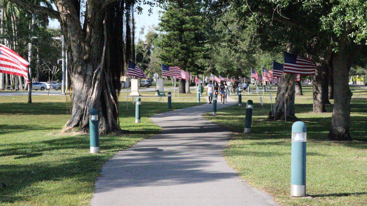 Some residents are offended that 50 American flags placed along Miami Springs’ popular Curtiss Parkway walking path contain the hashtag #OneNation.