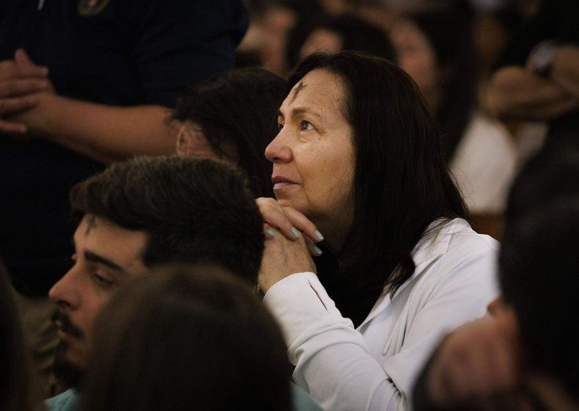 A woman sheds a tear while praying after receiving ashes during Ash Wednesday mass on Wednesday, Feb. 18, 2026, at Gesu Catholic Church in downtown Miami. 