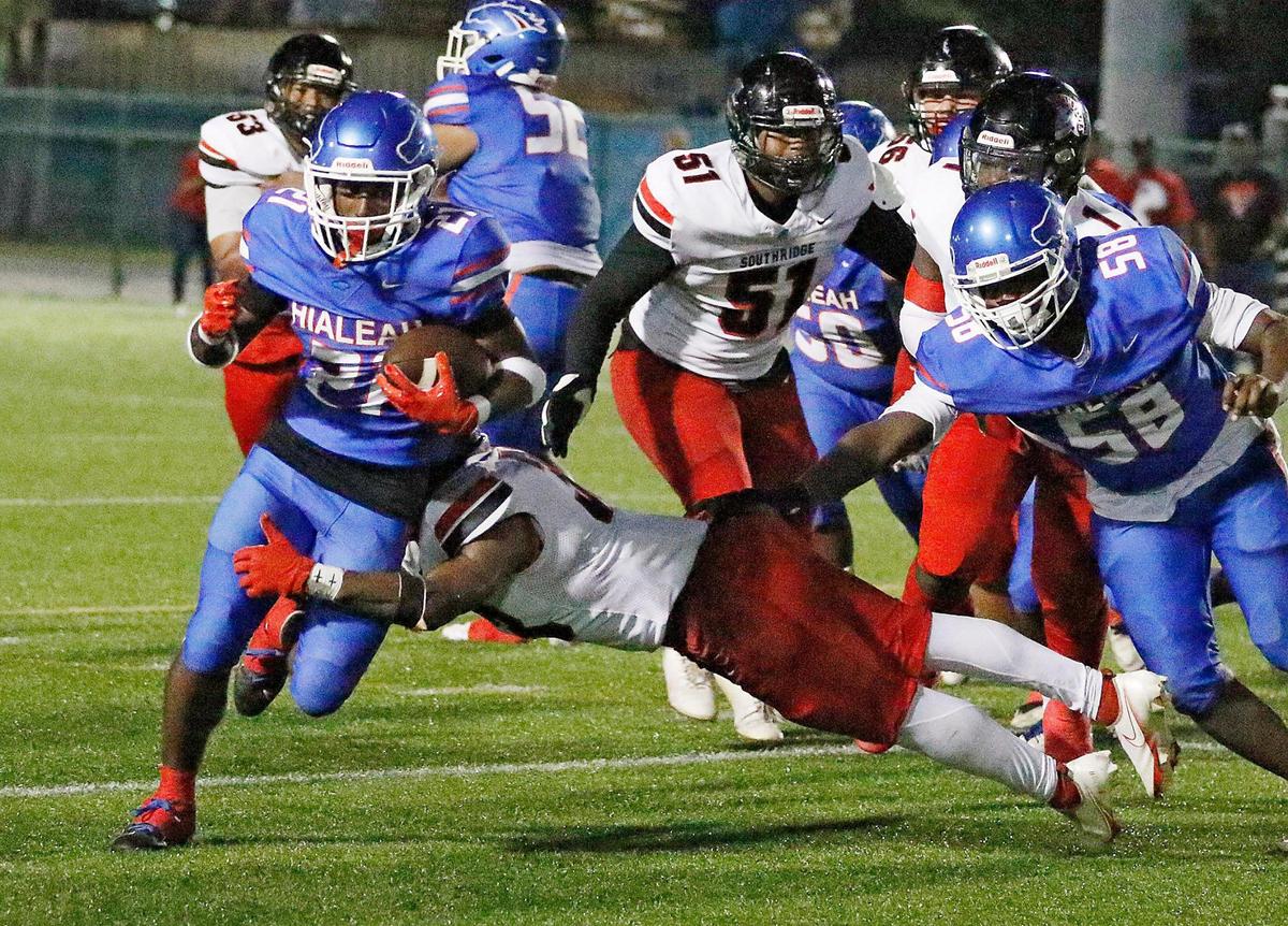 Hialeah Thoroughbreds running back Demetrius Brunson (21) tries to break free from Southridge Spartans defender during the first round playoff football game on Friday, November 10, 2023 at Ted Hendricks Stadium in Hialeah. Andrew Uloza / for Miami Herald