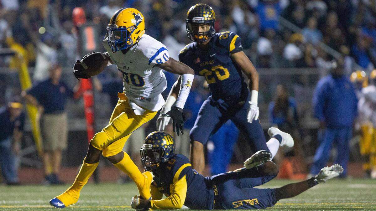 Miami Northwestern Romello Brinson breaks a tackle by Naples D’Andre St. Jean to score a touchdown, Friday, Nov. 30, 2018 at Naples’ Staver Field.