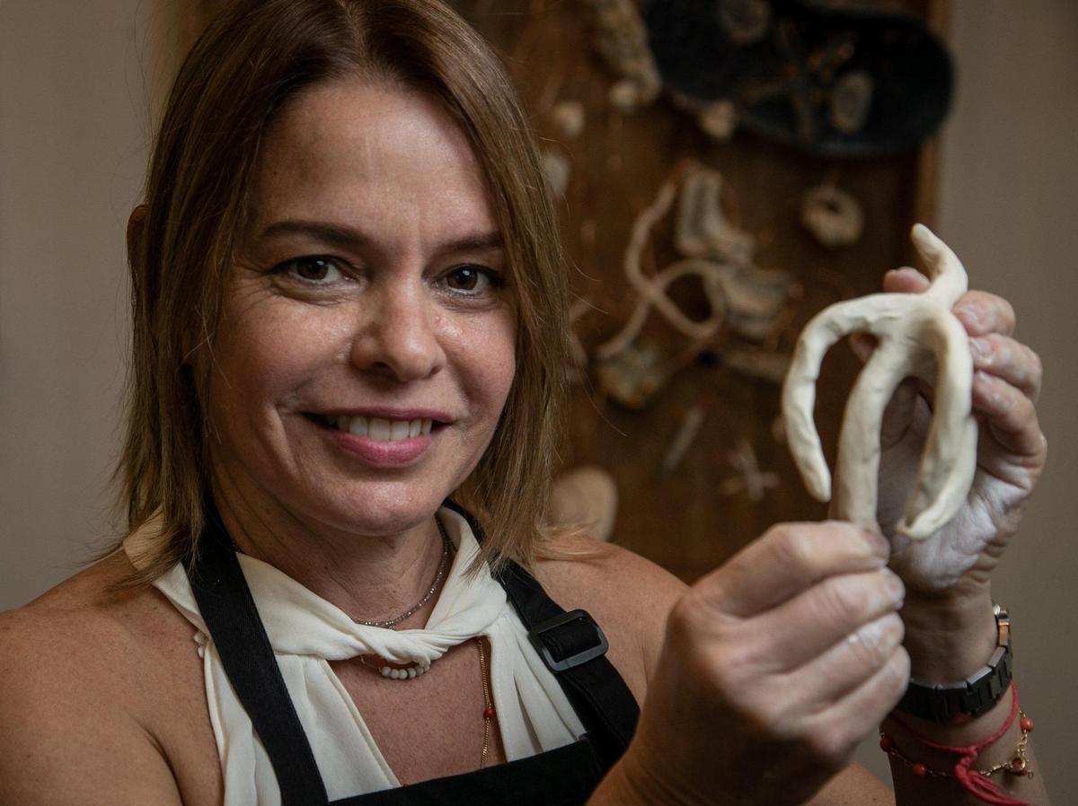 Coral Gables, Florida, Nov. 25, 2020: Laura Mármol, a ceramicist, makes a small figure of a coral inside the shop she shares with another artist along Miracle Mile. One property owner, Terranova, is letting artists use several vacant shops as studios and galleries through the end of the year.