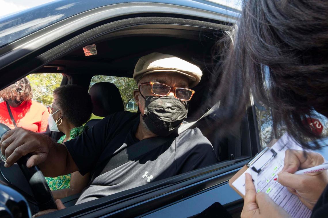 (L) Minister Michael Butler gives his name to (R) Kristina Jackson from Alpha Kappa Alpha Sorority, Inc. during “Stay Well Community Vaccine Event” at the Sweet Home Missionary Baptist Church, in Cutler Bay, on Saturday February 26, 2022.