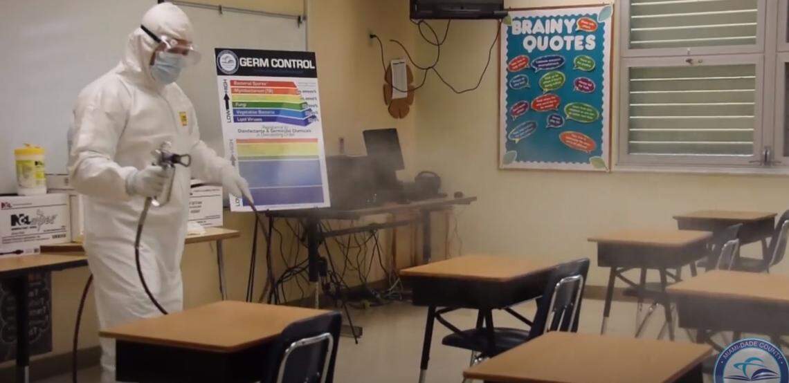 To limit the potential spread of COVID-19 in Miami-Dade County Public Schools, the district imposed various health-safety measures, such as enhanced cleaning of schools and buses. A screen grab of a district video shows a worker disinfecting a classroom.
