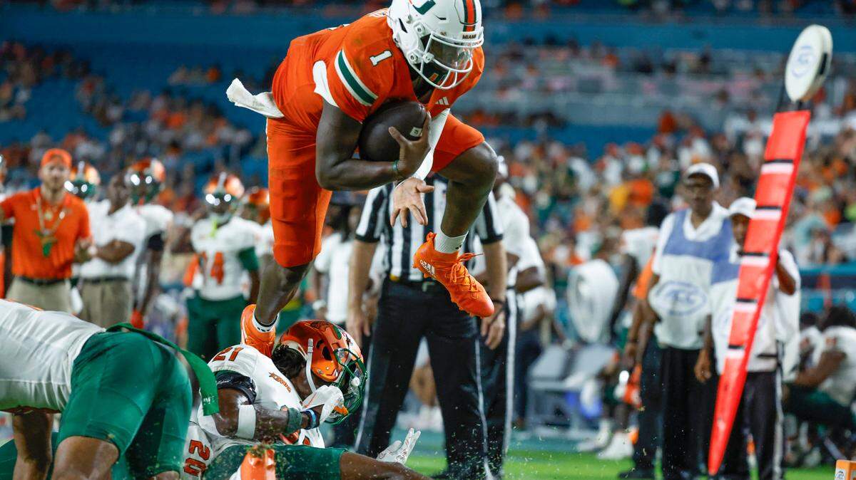 Miami Hurricanes quarterback Cam Ward (1) hurdles into the endzone to score against the Florida A&M Rattlers in the second half at Hard Rock Stadium in Miami Gardens, Florida, on Saturday, September 7, 2024.