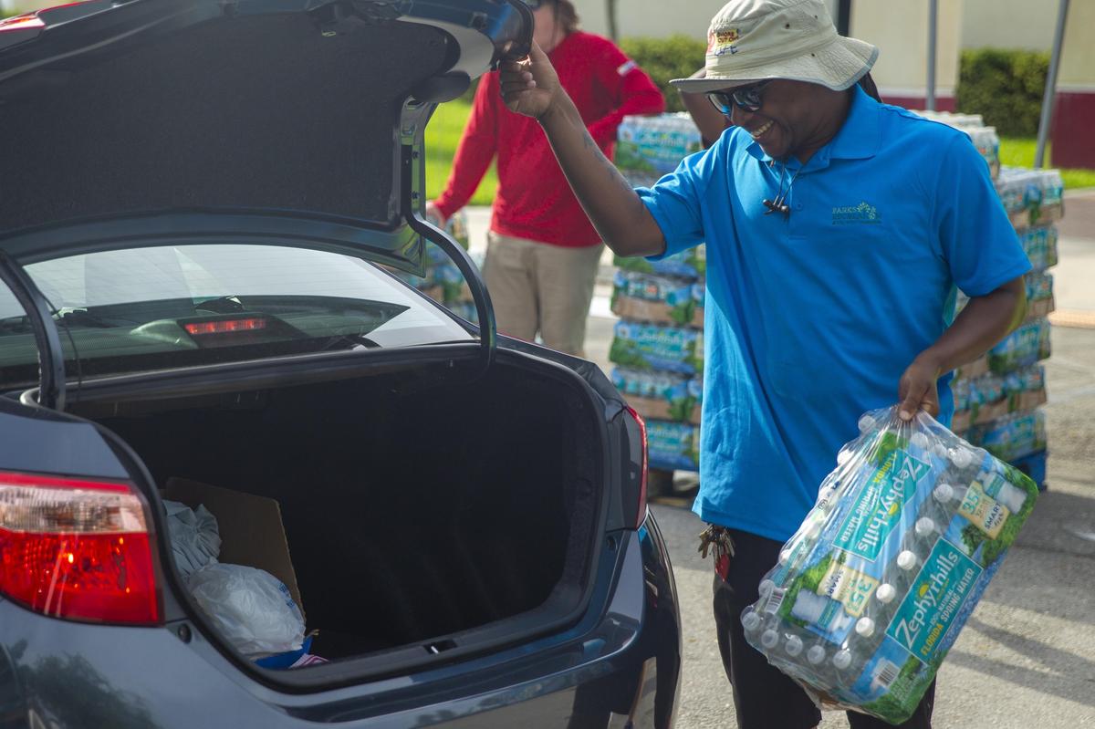 City of Fort Lauderdale employee Willie Brown helps distribute packs of water bottles to the city’s residents at a water distribution center in Riverland Park in Fort Lauderdale, Florida, on Thursday, July 18, 2019.