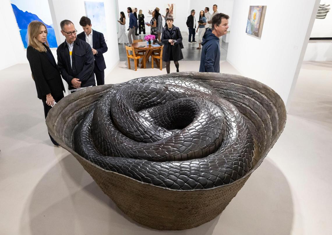 Festivalgoers at Art Basel at the Miami Beach convention center look at ‘Nyoka’ by Wangechi Mutu presented by Galdstone.