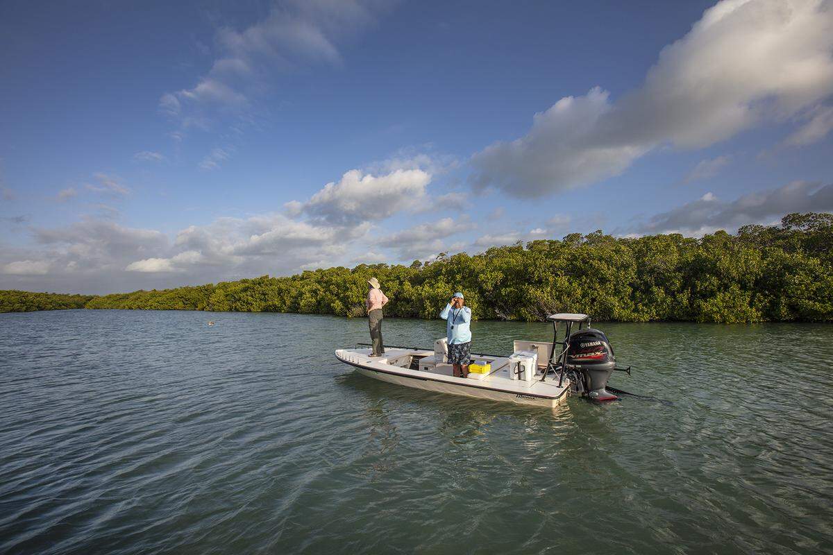Islamorada, Florida: Florida Keys Fishing Captain Tim Klein uses a small device to check water salinity while looking for fish with a fly fishing client off of Islamorada in Florida Bay.