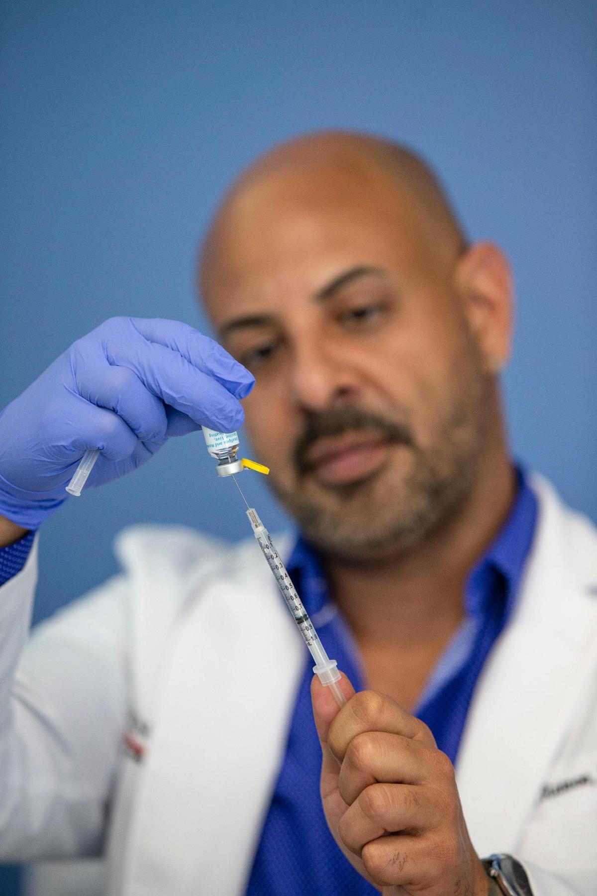 Nurse practitioner Joel Ramos prepares a dose of the monkeypox vaccine for a patient at Latinos Salud in Wilton Manors, Florida, on Wednesday, July 20, 2022.
