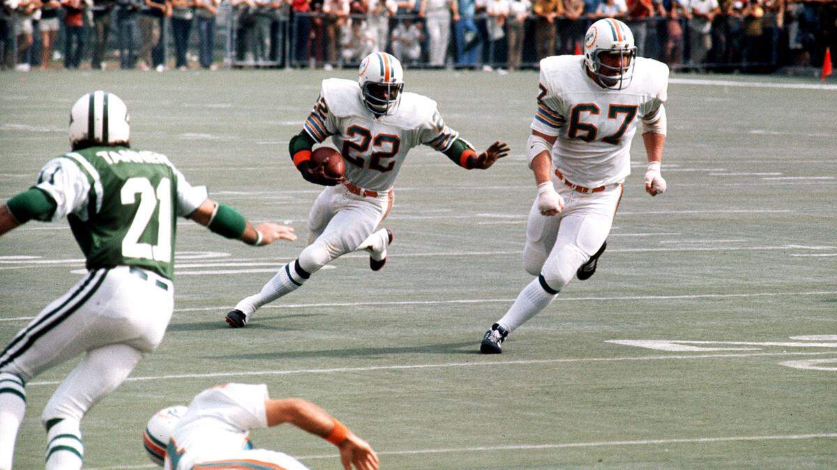 Miami Dolphins lineman Bob Kuechenberg (67) leads the way for running back Mercury Morris.