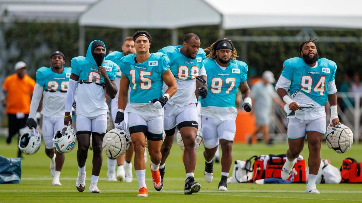 Miami Dolphins linebacker Jaelan Phillips (15) take the field alongside teammates during NFL football training camp at Baptist Health Training Complex in Hard Rock Stadium on Sunday, August 7, 2022 in Miami Gardens, Florida.