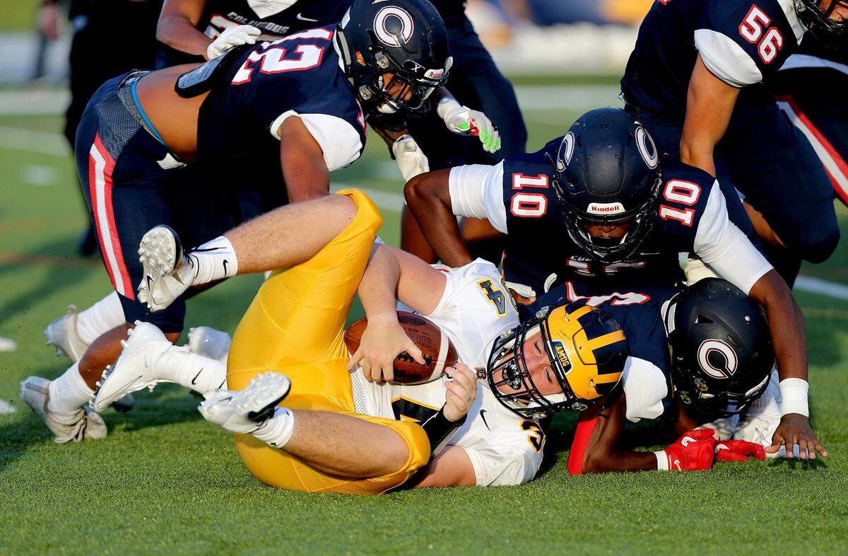 Belen’s Hayden Fuentes #34 (FB), gets tackled by Columbus players -from left- Sebastian Borges #12, Jabari Ishmael #10 and Ken Moore Jr. #6, in the first quarter as Columbus takes on Belen at Tropical Park, in Miami on Wednesday August 21, 2019.