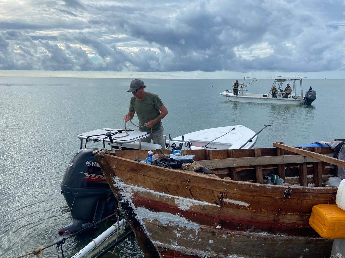 Florida Keys fishing guide Mark Cockerham ties a tow rope from a Cuban migrant boat to his vessel Friday, Oct. 14, 2022, on Indian Key. Since the Keys has seen a marked increase in migrant vessels littering the coast, Cockerham said he has been towing them to be preserved.