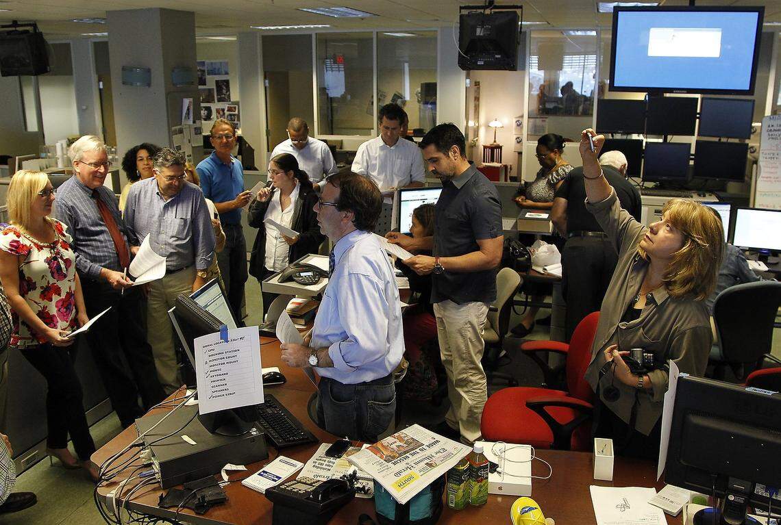 The final newsroom meeting at One Herald Plaza in May 2013, with editors gathered around the news desk to update each other on the day’s stories.