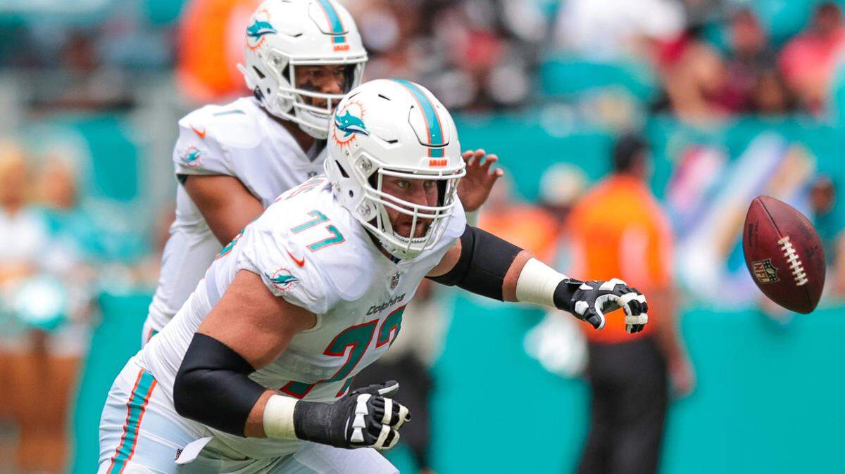 Miami Dolphins guard Jesse Davis (77) blocks as Dolphins quarterback Tua Tagovailoa (1) prepares to take the snap during first quarter of an NFL football game against the Atlanta Falcons at Hard Rock Stadium on Sunday, October 24, 2021 in Miami Gardens, Florida.