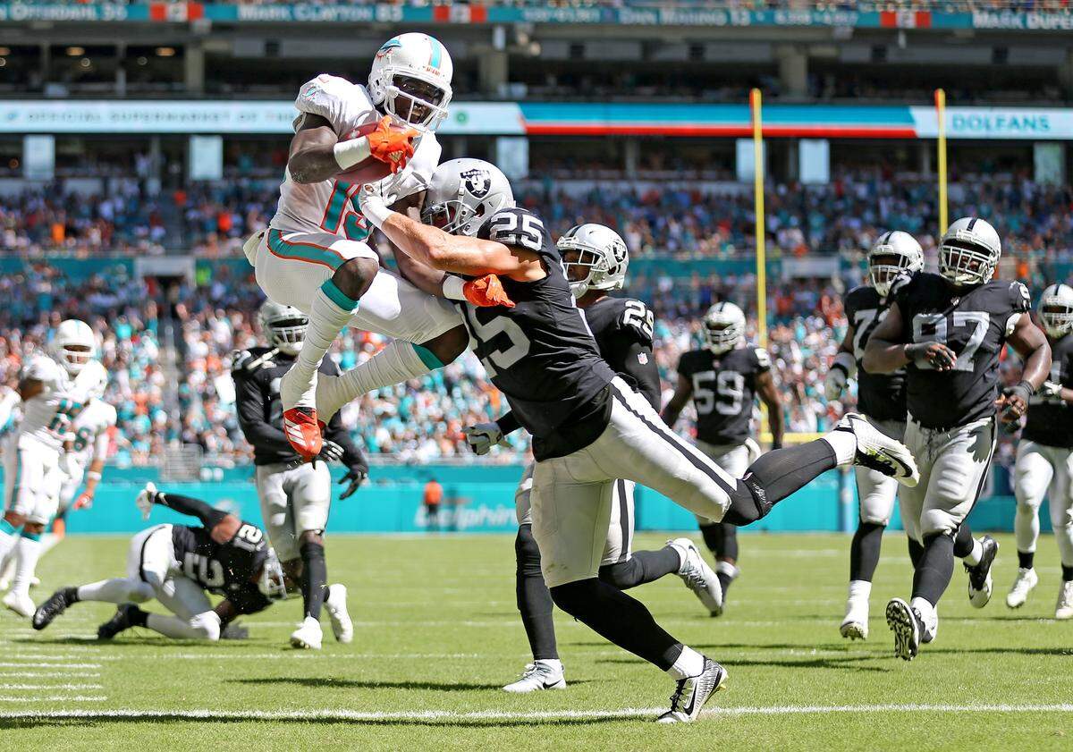 Miami Dolphins Jakeem Grant (19) leaps into the end zone for a touchdown as Oakland Raiders Erik Harris (25) fails to defend in the third quarter at Hard Rock Stadium Fl, Sunday, September, 23, 2018.