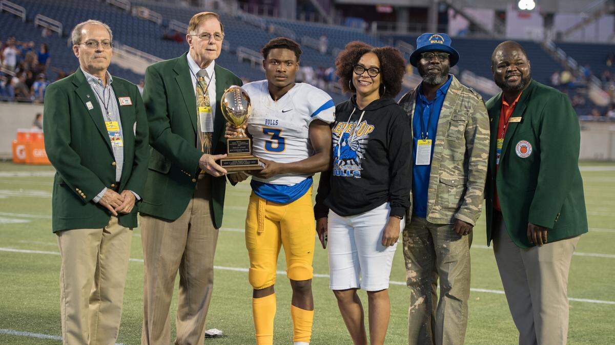 The Junior Orange Bowl Committee recently recognized Jaquez Stuart of Miami Northwestern High School with the Henry O. Langston Scholar Athlete Award. From left, Junior Orange Bowl committee members David Rowen, Henry O. Langston, Jaquez, his parents Sandra and James Stuart, and Junior Orange Bowl President Frandley DeFilie.