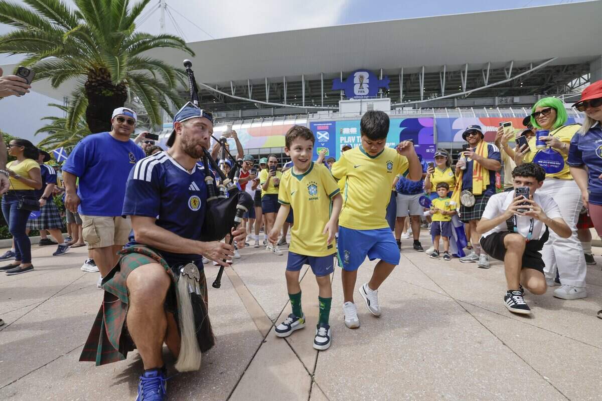 Lucas Sartori, 6, and Rafael Cardoso, 8, dance as Mark Love plays his bag pipe before the start of the World Cup Group C soccer match between Scotland and Bazil at Hard Rock Stadium (Miami Stadium) on Wednesday, June 24, 2026, in Miami Gardens, Fla.
